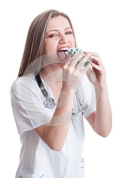 Female doctor taking a lot of blisters of pills photo