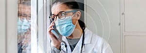 Female doctor talking on the cell phone looking out the window