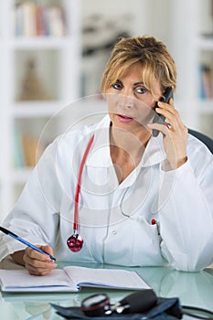 Female doctor talking on phone in diagnostic center