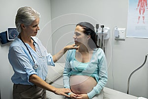 Female doctor talking with pregnant woman in examination room