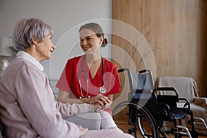 Female doctor talking to her patient during home visit