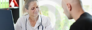 Female doctor is talking to her patient in medical clinic office.