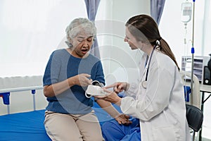 A female doctor talks to an elderly female patient while looking at her test results.