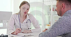 Female doctor talks to patient during visit to doctor office