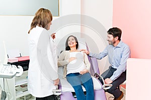 Female doctor telling a pregnant couple the sex of their baby
