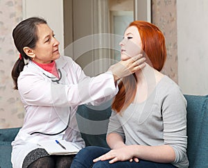 Female doctor touching neck of teen