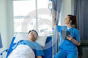 Female doctor treating young male patient in bed and talking with Asian male patient beside bed