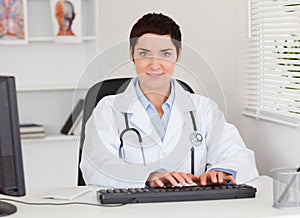 Female doctor typing with her computer