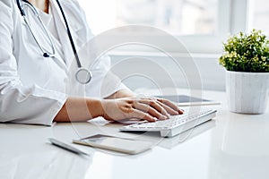 Female doctor typing on keyboard