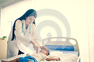 The female doctor uses two fingers to press down the center of the baby`s chest as a way to pump the heart.