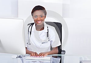 Female Doctor Using Computer At Desk In Hospital