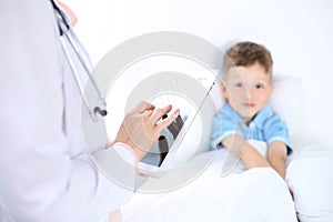 Female doctor using a digital tablet, close-up of hands. Health care concept or children`s therapy