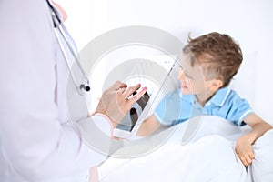 Female doctor using a digital tablet, close-up of hands. Health care concept or children`s therapy