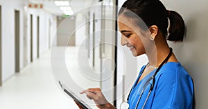 Female doctor using digital tablet in corridor