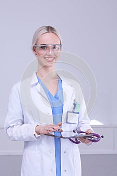 Female doctor using a digital tablet and standing on white background. Woman doctors.