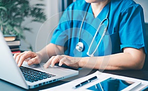 Female doctor using her laptop computer for employees management, hospital workflow and clinic staff solution on software or app.