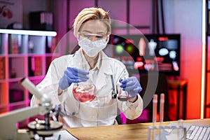 Female doctor using microscope with vacuum tubes for samples with COVID 19 infection