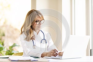 Female doctor using notebook while working photo