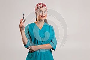 Female doctor with vial and syringe in hospital. Vaccination day. beige background