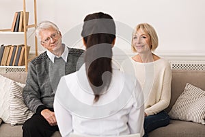 Female Doctor Visiting Senior Couple, Talking To Them
