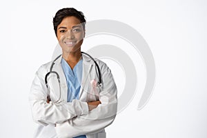 female doctor wearing breast cancer awareness pink ribbon with crossed arms