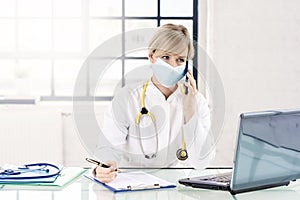 Female doctor wearing face mask while working in the doctor`s office