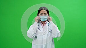 Female doctor wearing a mask on the green screen