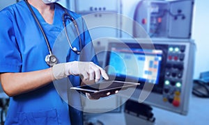 Female Doctor Wearing Scrubs In Hospital Using Digital Tablet