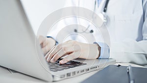 Female doctor working with laptop computer in her office for electronic medical record, disease analysis, checking medical results