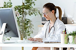Female doctor working with laptop in the office.