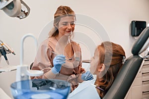 Female doctor is working with little girl. In the stomatological cabinet