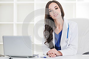 Female doctor working at office desk