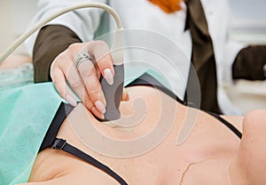 Female doctor working with an ultrasound scanner examining a heart area