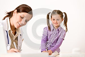 Female doctor write prescription for child