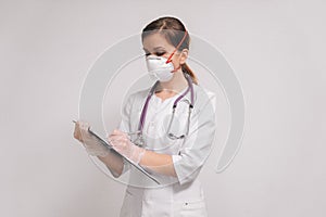 A female doctor writes a diagnosis of the patient. the doctor in a respirator