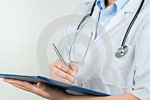 Female doctor writing medical information in notebook at hospital