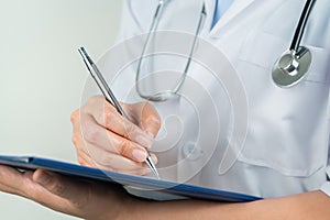 Female doctor writing medical information in notebook at hospital