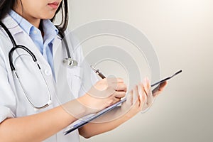 Female doctor writing medical information in notebook at hospital