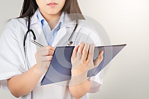 Female doctor writing medical information in notebook at hospital