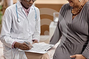 Female Doctor Writing in Medical Questionnaire