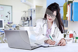Female doctor writing medical report