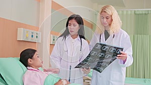 Female doctors explain X-ray film to a patient in a hospital.