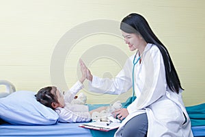 Female doctors perform physical examination on small children on the bed.