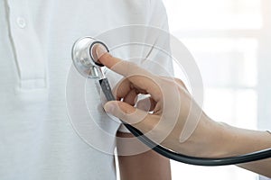 Female doctors perform a pulse examination using a headphone cable. Initial health check-up at the hospital. Medical and health