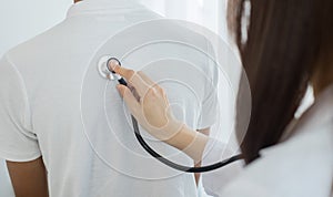 Female doctors perform a pulse examination using a headphone cable. Initial health check-up at the hospital. Medical and health