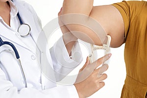 Female doctors use the Fat Caliper to measure fat in the arms of obese women.