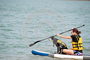 Female with a dog on the paddle board