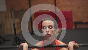 Female doing barbell thruster exercise in gym