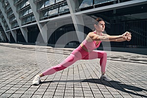 Female doing side lunge with locked hands