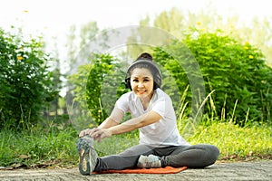 Female doing stretching exercise for legs, Young fitness healthy woman warm up before running or jogging in the park in sunshine